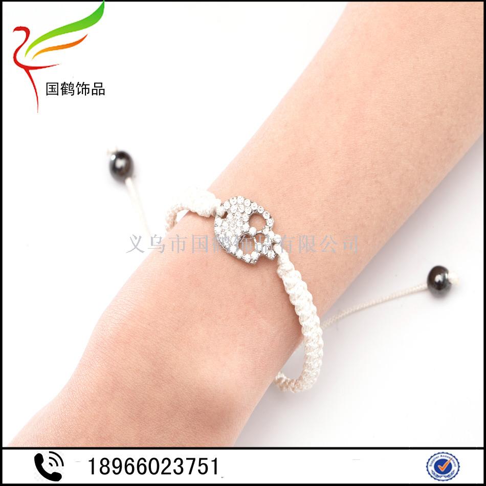 Diamond-encrusted skull with hand woven men's bracelet. Diamond-encrusted skull with hand woven men's bracelet.