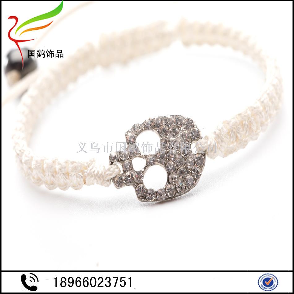 Diamond-encrusted skull with hand woven men's bracelet. Diamond-encrusted skull with hand woven men's bracelet.