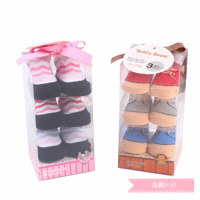Three pairs of baby shoes in a gift box