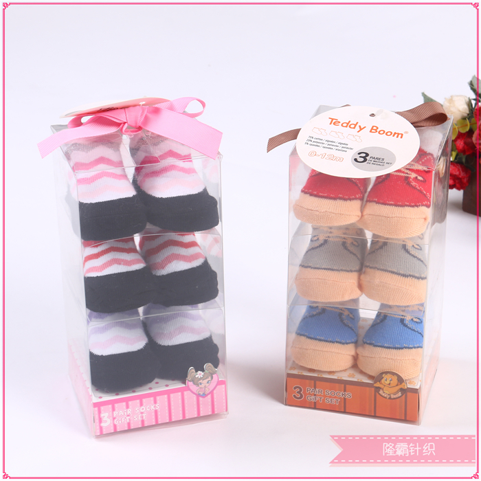 Three pairs of baby shoes in a gift box