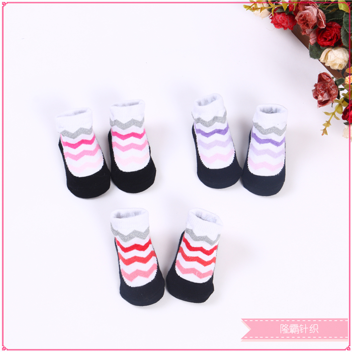 Three pairs of baby shoes in a gift box